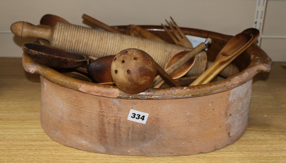 A terracotta bowl, a pill roller and a collection of wood spatulas, forks, spoons, etc,